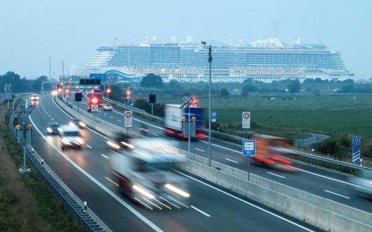 Berufsverkehr am Emstunnel, im Hintergrund das Kreuzfahrtschiff AIDAnova